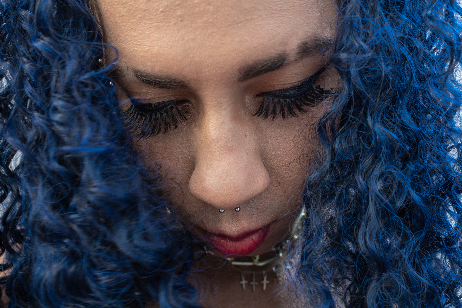 Retrato de Bárbara com cabelo azul durante evento do projeto Transgressoras em São Paulo. Bárbara costuma mudar de cabelo com frequência, do longo ao curto e com diversas colorações.