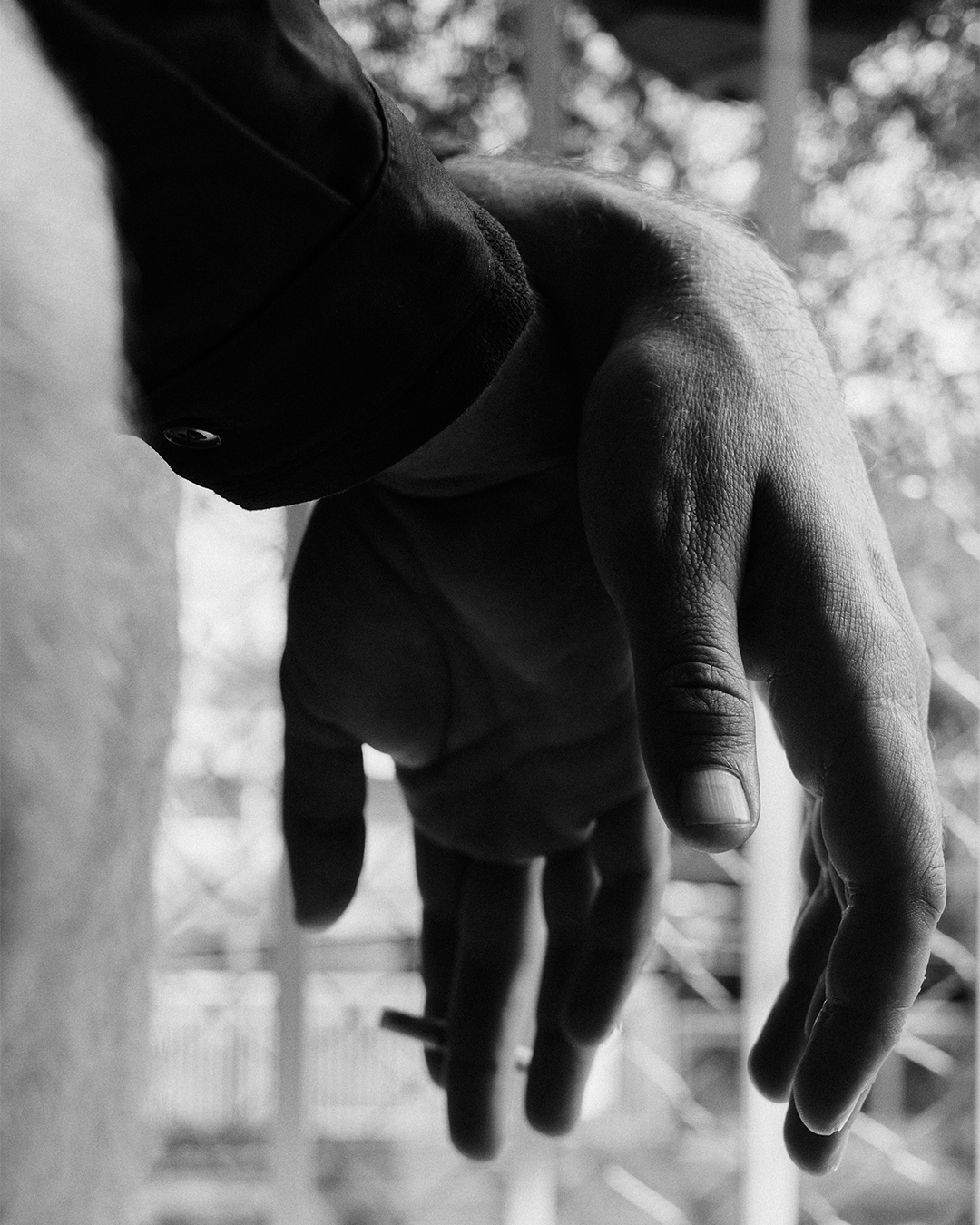 Mãos de Alejandro Claveaux cruzadas. Foto preto e branco.